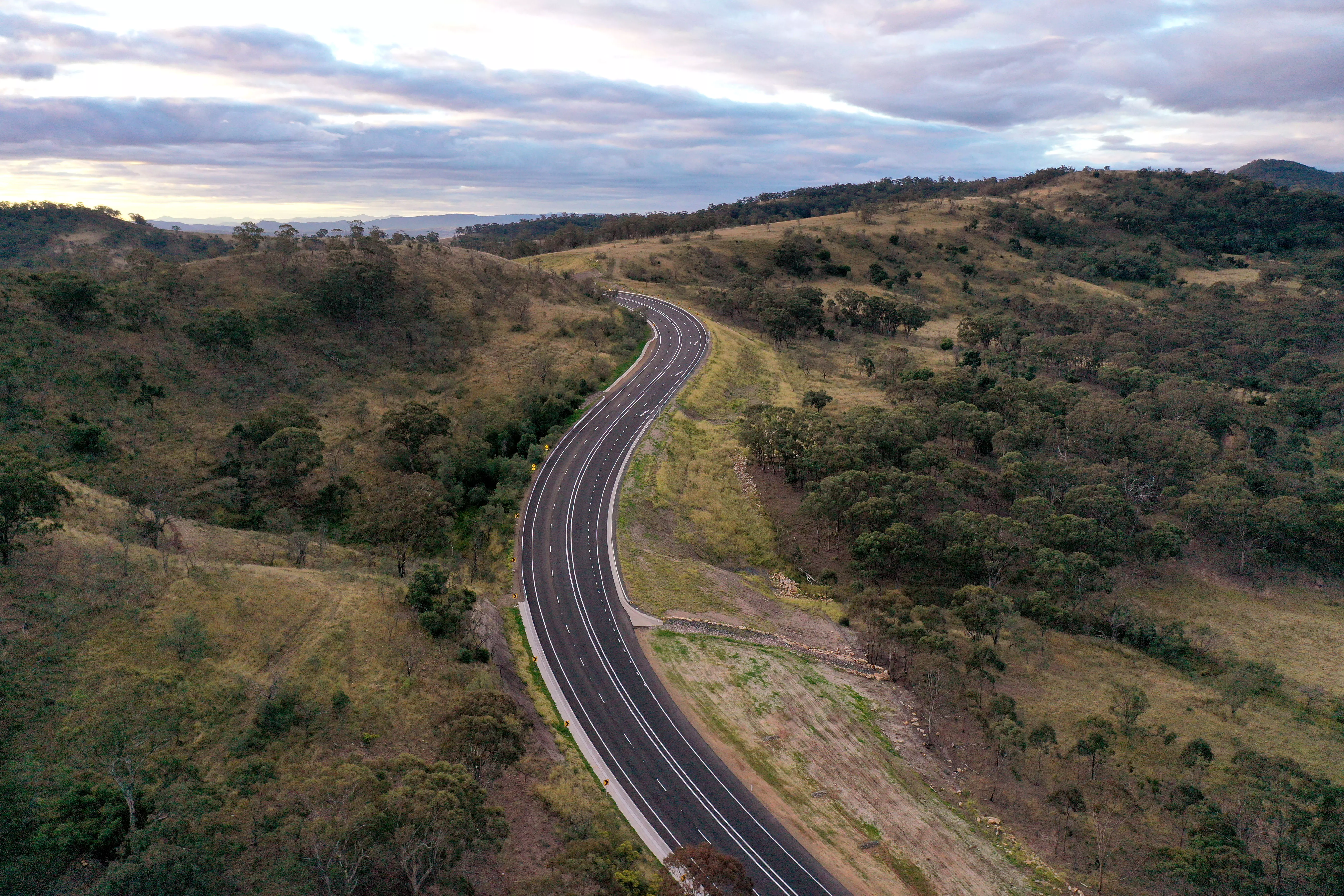 Road between green fields